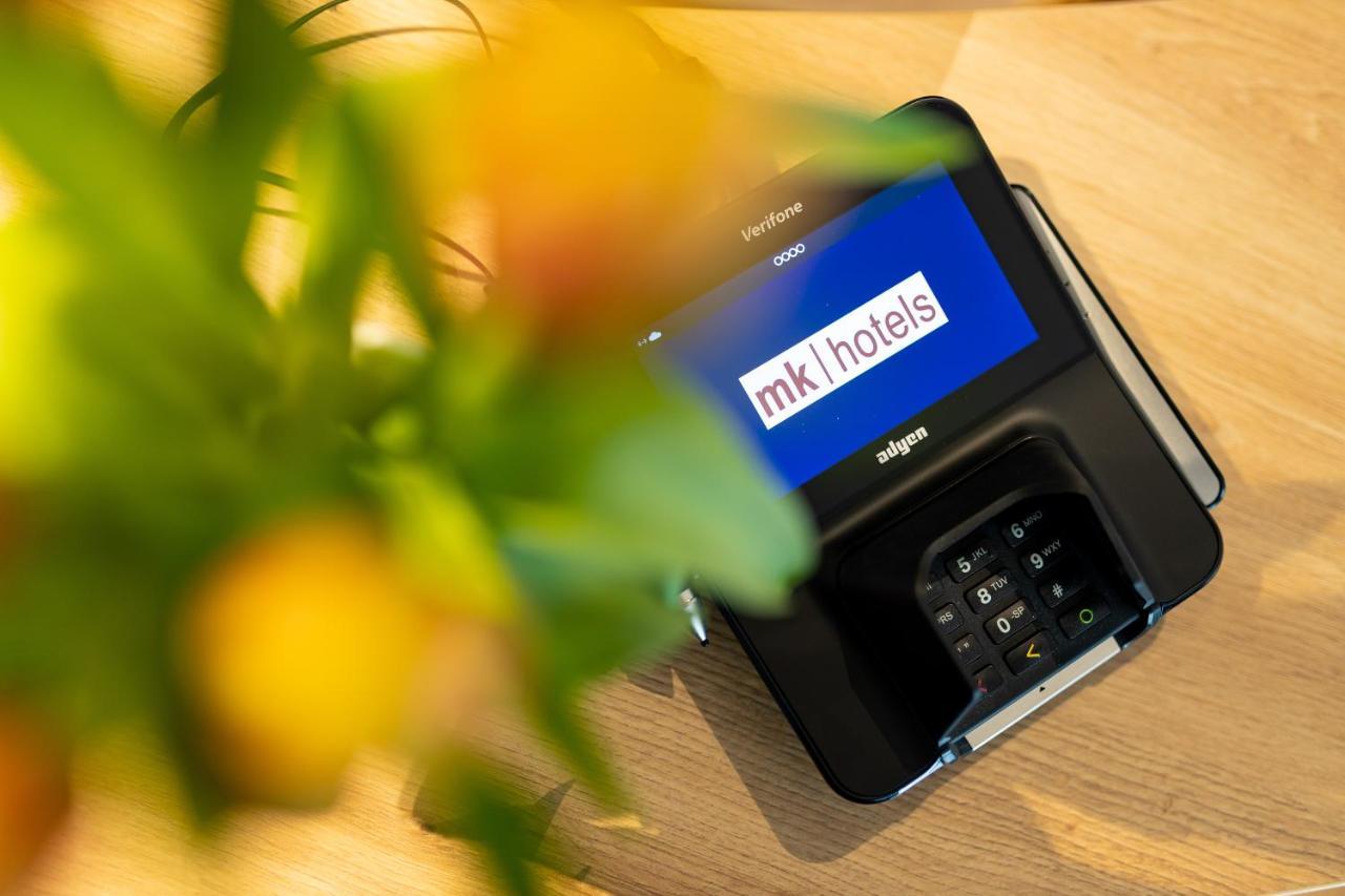 Mk Hotel Tirana Rinas 외부 사진 A mobile phone with the MK1Hotels logo on the screen